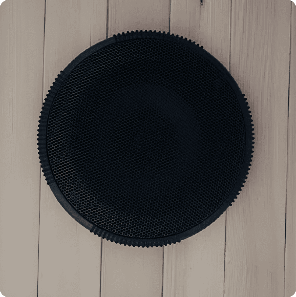 Black round mat on wooden floor